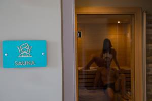 a man in a hotel room with a sign on the door at Principe Alogna Hotel & SPA in Altavilla Milicia