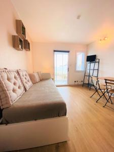 ein Wohnzimmer mit einem Bett und einem Tisch in der Unterkunft Appart Bréti Plage 1 - avec parking in Brétignolles-sur-Mer