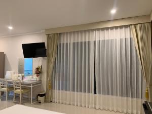 a room with a table and a curtain at Siri Ville Hotel in Si Sa Ket