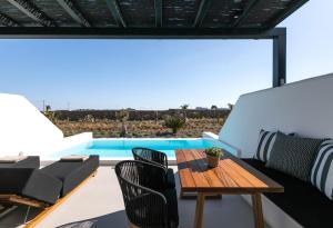 a patio with a table and chairs and a pool at Agrari Bo Suites in Agrari