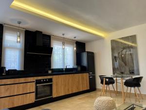 a kitchen with black cabinets and a table and chairs at PUERTO BANUS Apartamento COCÓ in Marbella