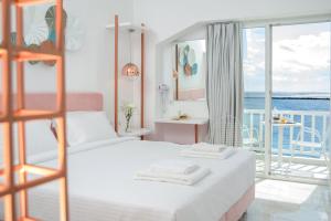 een slaapkamer met 2 bedden en uitzicht op de oceaan bij Nama Boutique Hotel in Tinos Town