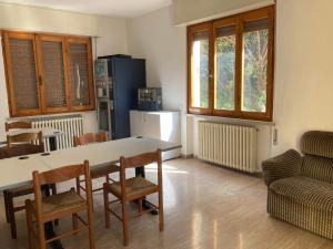 a kitchen with a table and chairs and a refrigerator at Route77 hostel in Toscolano Maderno