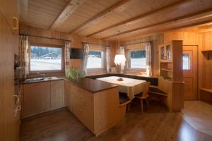 a kitchen with a table in the middle of a room at Almhütte Tirler Schweige in Alpe di Siusi