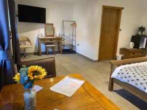 a living room with a table and a bed and a desk at Bumble Barn Bed & Breakfast in North Walsham