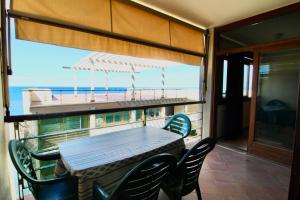 einen Tisch und Stühle auf einem Balkon mit einem Boot in der Unterkunft Lanterna 37 in San Vincenzo