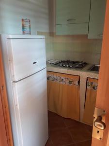 una cucina con frigorifero bianco e piano cottura di Camera con angolo cottura "Torre Vado" a Morciano di Leuca