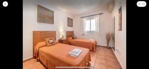 Una habitación de hotel con dos camas y una ventana. en Can Andrea, en Ibiza