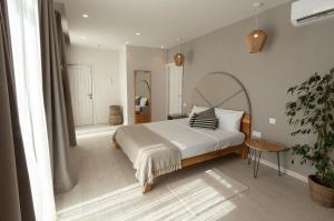 a bedroom with a large bed and a plant at Villa dei Venti in Qala
