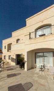 a building with a patio with chairs and a table at Villa dei Venti in Qala