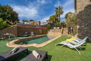 una piscina con tumbonas en un patio en Castillo Can Xirau, Propiedad Exclusiva con piscina & aircon, en Santa Susanna