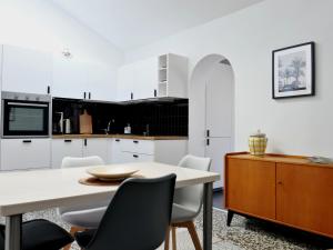 a kitchen with white cabinets and a table and chairs at Palm House 10 in Benalmádena