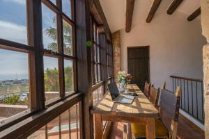 a balcony with a table with a laptop on it at Castillo Can Xirau Piscina Privada Vistas Mar Aire Acondicionado in Santa Susanna