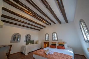 a bedroom with two beds and two windows at Castillo Can Xirau Piscina Privada Vistas Mar Aire Acondicionado in Santa Susanna