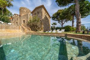 a swimming pool in front of a building with a castle at Castillo Can Xirau Piscina Privada Vistas Mar Aire Acondicionado in Santa Susanna