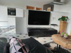 a living room with a black leather couch and a flat screen tv at Ferienwohnung Stahl in Muhr amSee