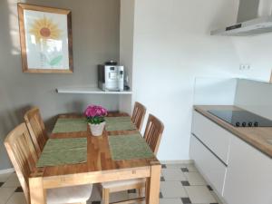a kitchen with a wooden table with chairs and a kitchen counter at Ferienwohnung Stahl in Muhr amSee