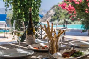 einen Tisch mit einer Flasche Wein und zwei Gläsern in der Unterkunft Armonia Bay Hotel in Kokkari