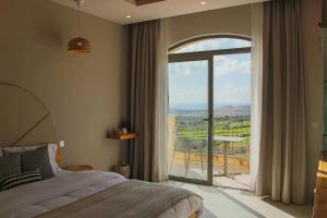 a bedroom with a bed and a balcony with a view at Villa dei Venti in Qala