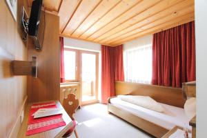 pokój hotelowy z łóżkiem i oknem w obiekcie Pension Mittagskogel w mieście St. Leonhard im Pitztal