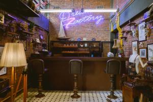 a bar with a neon sign on a brick wall at Dream Factory Hotel in Udon Thani