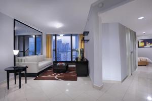 Horison Ultima Suite & Residences Rasuna Jakarta في جاكرتا: غرفة معيشة مع أريكة وطاولة