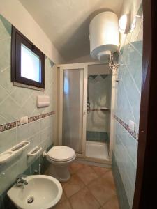 een badkamer met een toilet, een wastafel en een douche bij Appartamenti Cala d'Ambra in San Teodoro