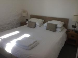 a bedroom with a white bed with towels on it at Mill Lodge in Wells