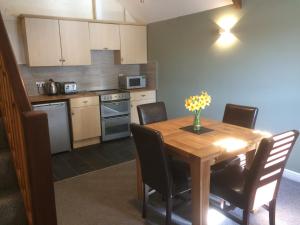 a kitchen with a wooden table with chairs and a table and a table at Mill Lodge in Wells