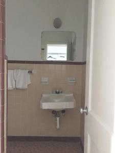 uma casa de banho com um lavatório e um espelho em Economy Inn em Lumberton