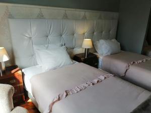 a bedroom with two beds and a lamp and a chair at Casa Azul Hostel in Sintra