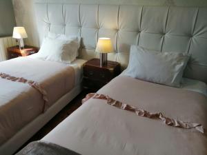 a hotel room with two beds with a large headboard at Casa Azul Hostel in Sintra