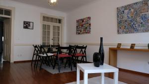 uma sala de estar com uma mesa de jantar e cadeiras em Apartamento central para grupo ou familias em Lisboa
