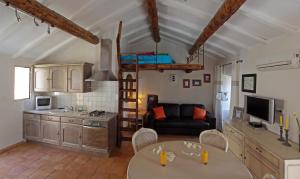 a kitchen and living room with a couch and a table at Latu Corsu - Côté Corse - Gites et chambres d'hôtes au Cap Corse in Ersa