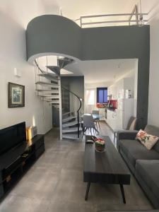 ein Wohnzimmer mit einem Sofa und einer Wendeltreppe in der Unterkunft Cosy apartment in the heart of Kato Paphos in Paphos City
