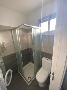 ein Bad mit einem WC und einer Glasdusche in der Unterkunft Cosy apartment in the heart of Kato Paphos in Paphos City