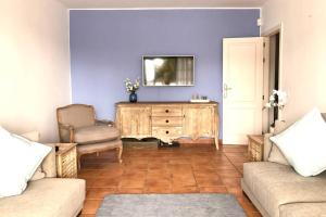 a living room with a couch and a tv on a purple wall at Casa Esperanza, 2 Bedroom Duplex Puerto Calero in Puerto Calero