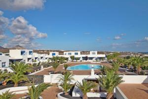 a view of a resort with a pool and palm trees at Casa Esperanza, 2 Bedroom Duplex Puerto Calero in Puerto Calero