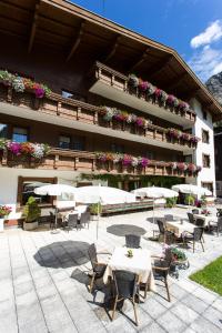 hotel ze stołami i krzesłami przed budynkiem w obiekcie Pension Mittagskogel w mieście St. Leonhard im Pitztal