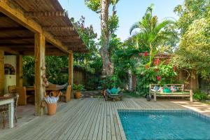 a backyard with a swimming pool and a wooden deck at Casa da Glória Trancoso in Trancoso