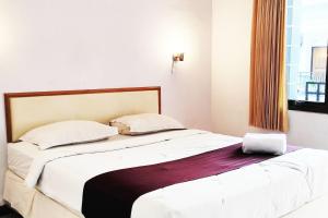 Postel nebo postele na pokoji v ubytování Hotel Salma Syariah Mitra RedDoorz near Terminal Baru Kediri