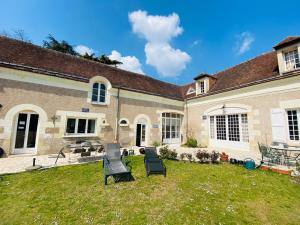 a house with two lawn chairs in the yard at Maison des Arts Francueil in Francueil