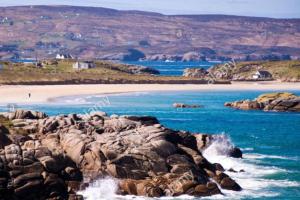 a beach with rocks in the water and a beach at Atlantic View Apartment in Dungloe