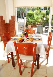 una mesa de madera con comida en la parte superior de un patio en Ilion, en Loutraki