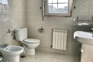 bagno con servizi igienici, lavandino e specchio di Casa Fonte Barreira - Camariñas a Camariñas