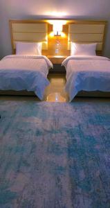 a bedroom with two beds and a room with at شقق Flower-z in AlUla