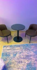 2 sillas y una mesa en una habitación en شقق Flower-z en Al Ula