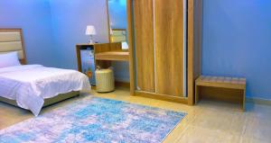 a bedroom with a bed and a mirror and a rug at شقق Flower-z in AlUla