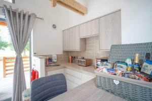 a kitchen with white cabinets and a blue chair at Wee Ness Lodge in Inverness