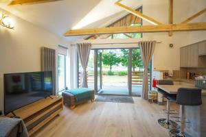 a living room with a flat screen tv and a table at Wee Ness Lodge in Inverness